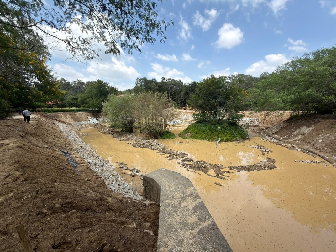 Bannerughatta Lake bed with stone-pitched banks and a vegetated island, with work in progress